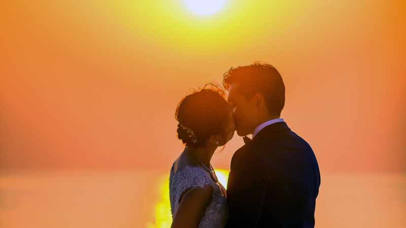 Thai couple in traditional wedding attire showing respect